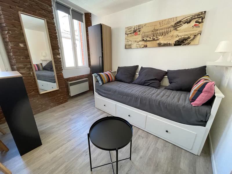 Séjour d'un studio de Saint-Cyprien géré par Takeys : verrière, canapé et parquet clair
